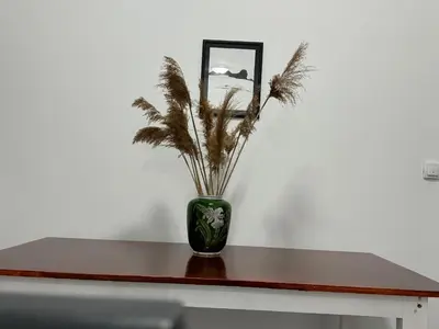 a green vase with a plant in it on a table at Belgrade Airport single bed in Surčin