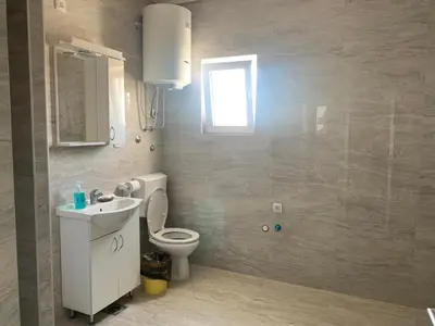 a bathroom with a toilet and a sink and a window at Deluxe Double Room Belgrade Airport in Surčin