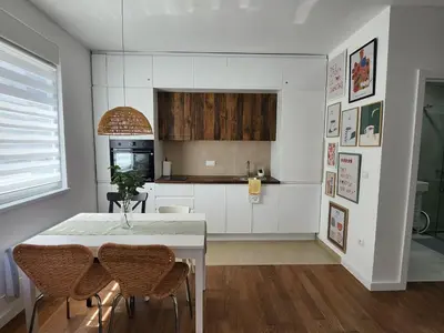 a kitchen with a table and chairs in a room at Apartment Endorfin - Modern apartment close to airport in Surčin