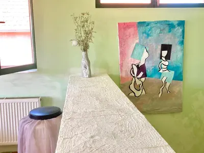 a room with a table with a vase and a painting at Artists Inn, large 2 bed duplex apartment, parking in Železnička Stanica Zemunsko Polje