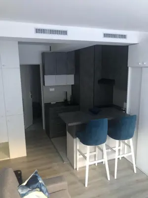 a kitchen with a table and two blue chairs at Beograd stan na dan in Novi Beograd