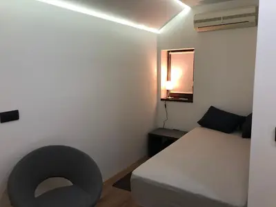 a small bedroom with a bed and a mirror at Apartment Nevena 3 in Belgrade