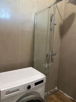 a shower stall with a washing machine in a bathroom at Amar1 in Belgrade