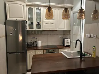 a kitchen with white cabinets and a stainless steel refrigerator at Vračar Elegance Apartment in Belgrade