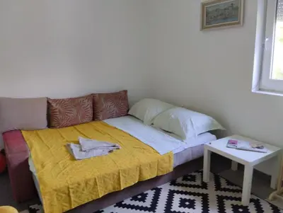a small bed in a room with a yellow blanket at Summer house in Belgrade in Slanci