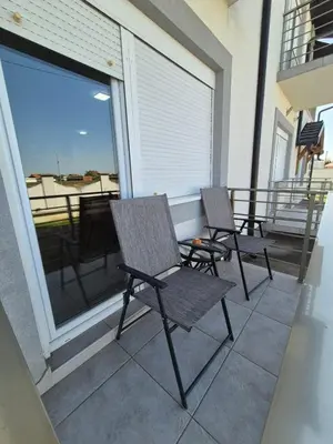 two chairs on a balcony with a view of the ocean at Rio Apartmani Ub 2 in Ub