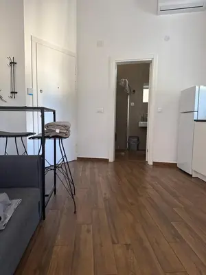 an empty living room with a table and a refrigerator at Amar3 in Belgrade