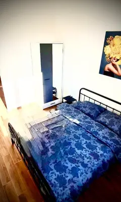 a bedroom with a bed with a blue comforter at Amar2 in Belgrade