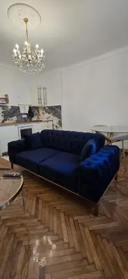 a blue couch sitting in a living room at Admiral Suite in Belgrade