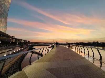 a bridge over a river with a sunset in the background at Beldorado Apartments - Belgrade Waterfront Azure Studio in Belgrade