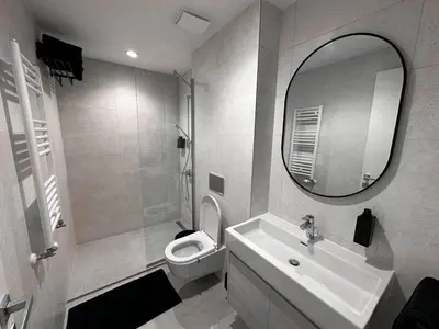 a bathroom with a sink and a toilet and a mirror at Beldorado Apartments - Belgrade Waterfront Azure Studio in Belgrade