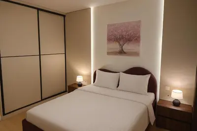 a bedroom with a bed with two lamps and a tree at Belgrade Waterfront LuX Sky Residence in Belgrade