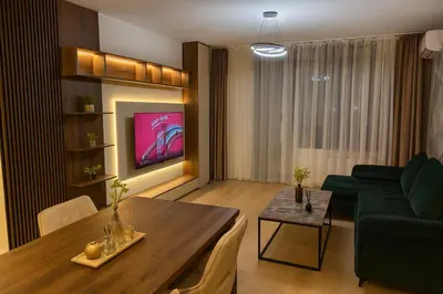 a living room with a table and a green couch at Belgrade Waterfront LuX Sky Residence in Belgrade