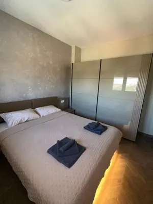a bedroom with a bed with two towels on it at The Wolf Residence in Inđija