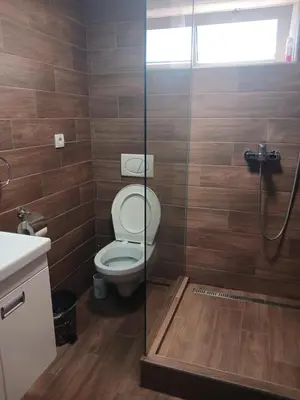 a bathroom with a toilet and a glass shower at Stan Na Dan Pancevo in Pančevo