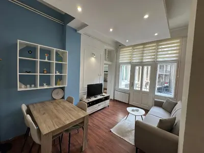 a living room with a table and a couch and a tv at Eight Apartment Two Bedroom City Centre Comfort in Belgrade