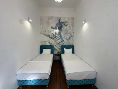 two beds in a room with a painting on the wall at Eight Apartment Two Bedroom City Centre Comfort in Belgrade