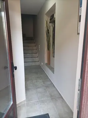 a hallway with a tile floor and stairs at Katera S in Zemun