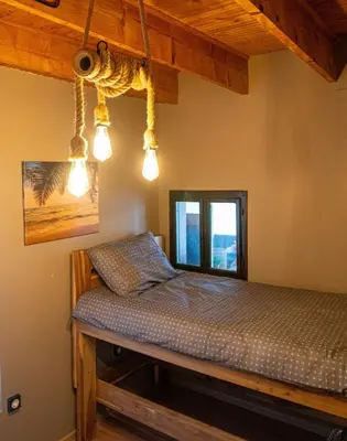 a bed in a room with lights hanging from the ceiling at Unique River Houseboat Stay in Železnička Stanica Senjak