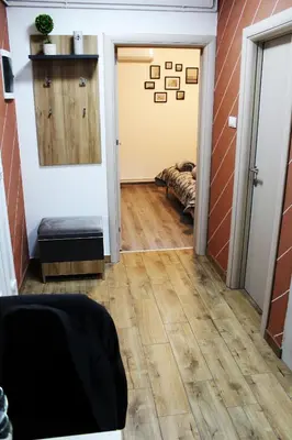 a hallway with wood floors and a door with a mirror at DEP House in Beograd