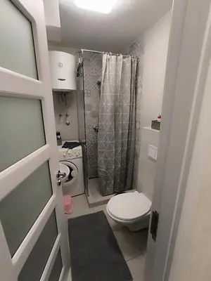 a small bathroom with a toilet and a shower at Nina Urban Apartment-Novi Beograd in Belgrade