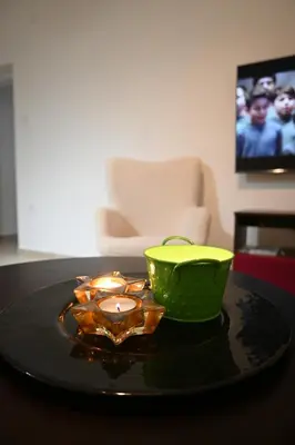 a green bowl and a candle on a table at Ellie Star Apartment in Belgrade
