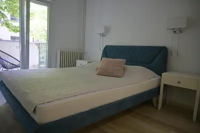 a bed with a blue headboard in a bedroom at Ellie Star Apartment in Belgrade