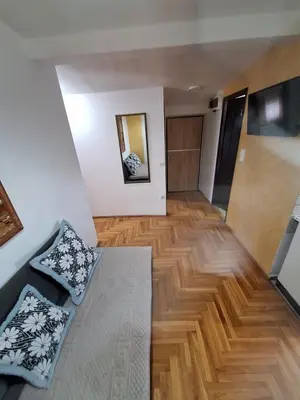 a living room with a couch and a wooden floor at Rooms1 in Beograd