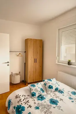 a bedroom with a bed and a wooden cabinet at Apartman Kalina in Belgrade