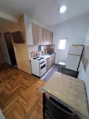 a kitchen with a table and a white stove top oven at Rooms3 in Beograd
