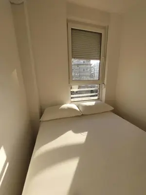 a small room with a bed and a window at DELTA CITY apartments in Novi Beograd