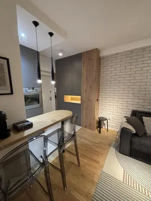 a kitchen and living room with a table and a couch at Urban Nest Belgrade in Belgrade