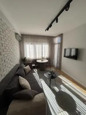 a living room with a couch and a brick wall at Urban Nest Belgrade in Belgrade