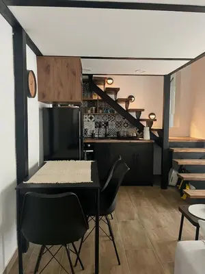 a dining room with a table and chairs and a staircase at City Loft in Belgrade
