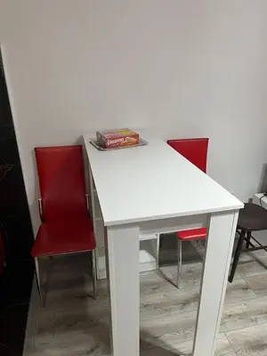 a white table with two red chairs and a book on it at Apartman Jovanović in Belgrade