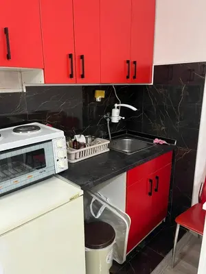 a kitchen with red cabinets and a sink at Apartman Jovanović in Belgrade