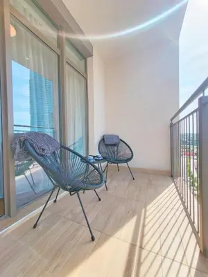 a balcony with two chairs in a room with a window at Eterna Premium Apartment 1 Bedroom in Sajmište