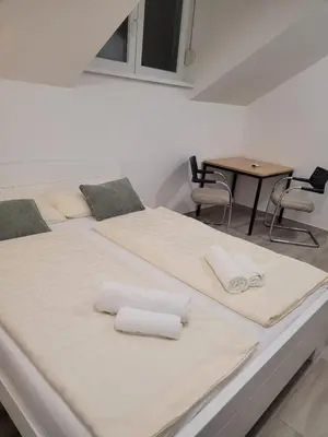 two beds in a room with a table at Beosan in Železnička Stanica Zemunsko Polje