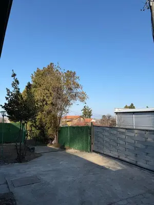 a driveway with a fence and trees in the background at Barrique apartments sa zatvorenim bazenom in Smederevo