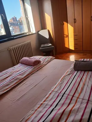 a large bed in a room with a large window at Apartman86 in Beograd