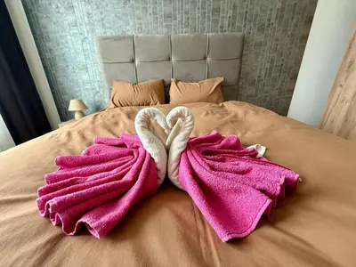 two towels in the shape of two hearts on a bed at Eden Apratment in Belgrade
