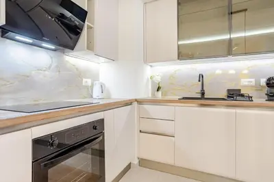 a white kitchen with white cabinets and a sink at Belgrade Waterfront - Beograd na vodi - Beograd in Belgrade