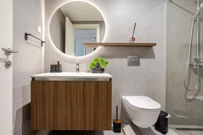 a bathroom with a sink and a toilet and a mirror at Belgrade Waterfront - Beograd na Vodi - Sensa 3 in Belgrade