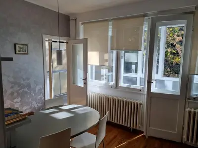 a dining room with a white table and windows at Apartment MHarmony#Vracar in Belgrade