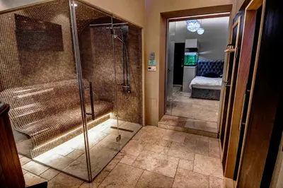 a bathroom with a walk in shower with a glass door at Apartments Marconio Wellness Club in Belgrade