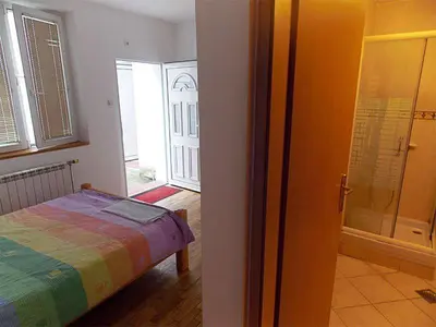 a bedroom with a bed and a walk in shower at Hostel Kavala in Belgrade