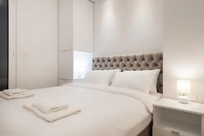 a bedroom with a white bed with towels on it at Vivio Luxury Apartment in Belgrade