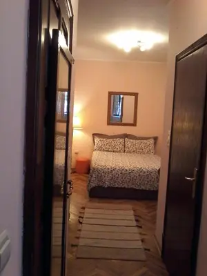a bedroom with a bed and a mirror and a door at Studio Hram in Belgrade
