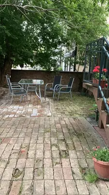 a patio with chairs and a table and a fence at Studio Hram in Belgrade
