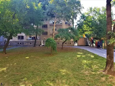a building in the background with trees in the foreground at Asya Blue Apartment in Belgrade